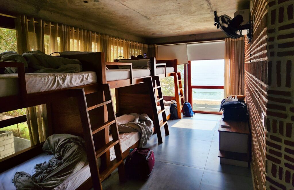 a room filled with lots of bunk beds next to a window